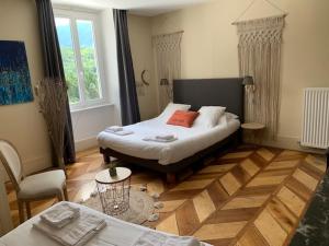 a bedroom with a bed and a chair and a window at Hôtel Restaurant Le Repère in Vizille