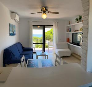 salon ze stołem i niebieską kanapą w obiekcie Beach Apartment Las Acacias Torrenueva w mieście La Cala de Mijas