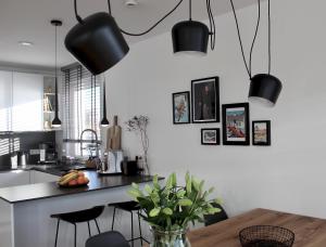 a kitchen with black pendant lights and a table at hey BEACHVILLA in Hohwacht