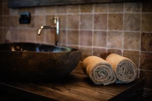 a bathroom sink with two rolled towels on a counter at Apartment Judith - Gallhof in Vollan