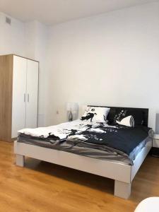 1 dormitorio con 1 cama grande con almohadas blancas y negras en Pokoje nad Drzewiczką, en Drzewica