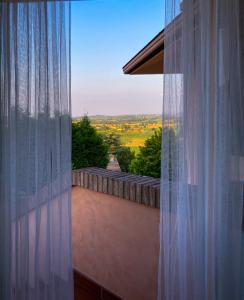 - une vue depuis une fenêtre dotée d'un rideau blanc dans l'établissement VILLA ISELLA, à San Venanzio