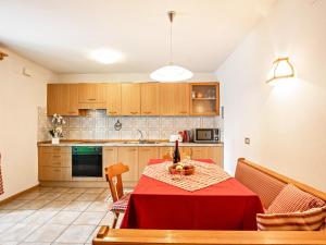 a kitchen with a table with a red table cloth at Ciasa Lino Sas da le Undesc in Pozza di Fassa +21 photos
