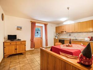 a kitchen with a table with a red table cloth at Ciasa Lino Sas da le Undesc in Pozza di Fassa