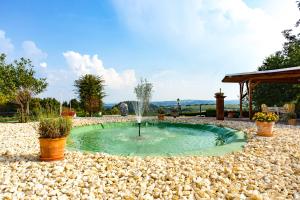 a small pool with a fountain in a gravel yard at Landhaus Kürrenberg in Mayen