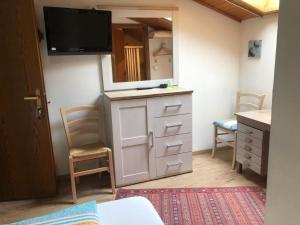 a bedroom with a dresser and a mirror at Garni Rebhof in Nalles