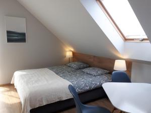 a bedroom with a bed and a desk and a window at Sosenka in Niechorze