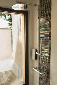 Grand-FougerayHÔTEL LES PALIS的浴室设有窗户和玻璃淋浴间。