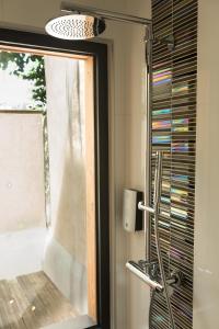 a bathroom with a window and a glass shower at HÔTEL LES PALIS in Grand-Fougeray