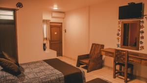 Schlafzimmer mit einem Schreibtisch und einem Bett sowie einem Schreibtisch sidx sidx sidx in der Unterkunft Los Ciruelos Oaxaca in Oaxaca de Juárez