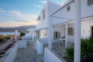 Casa blanca con terraza con mesa y sillas en Prasini Gonia en Platís Yialós Sifnos