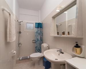 a white bathroom with a sink and a toilet at Blue Houses Apartments in Finikounta +52 photos