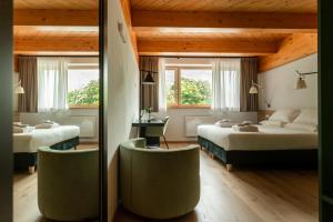 Habitación de hotel con 2 camas y 2 sillas en Foresteria Crotasc en Mese