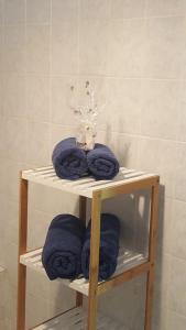 un estante con toallas azules en el baño en Maison Grande Anse, en Deshaies