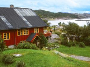 ein rotes Haus mit Sonnenkollektoren darüber in der Unterkunft Seven-Bedroom Holiday home in Flatanger 2 in Straum