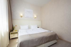 um quarto com uma cama grande e lençóis brancos em Helios em Bukovel