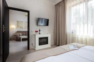 1 dormitorio con chimenea y TV en la pared en Helios en Bukovel