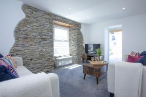 a living room with a stone wall at Ocean View, Newquay in Newquay