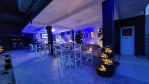 um restaurante com bancos brancos e um bar com luzes azuis em Grand Bahia Relaxury em Costinesti