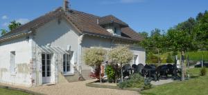 uma casa branca com cadeiras pretas em frente em ZooParc de Beauval, gite du vivier em Seigy