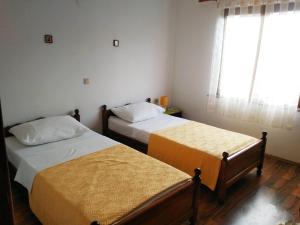 two beds in a small room with a window at Apartman Darko in Cesarica