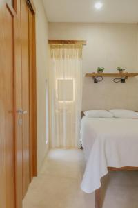 ein Schlafzimmer mit einem Bett und einer Tür mit einem Fenster in der Unterkunft Hostik Hostal in Mérida