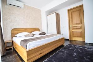 1 dormitorio con cama de madera en una habitación en Apart hotel Victor 203, en Mamaia