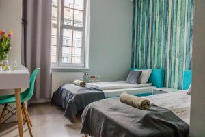 a room with two beds and a desk and a window at Trip & Hostel in Gdańsk
