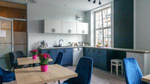a kitchen with blue cabinets and a table and chairs at Trip & Hostel in Gdańsk