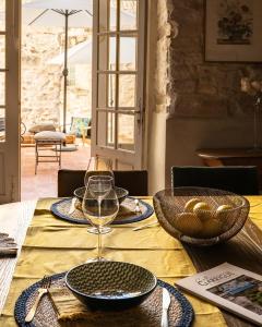 a table with a glass of wine on top of it at LA FUGUE chambres d' hôtes de charme , DEMEURE HISTORIQUE,PISCINE,JARDIN proche UZES NIMES ALES in Brignon