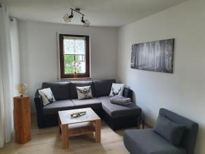 sala de estar con sofá y mesa en Ferienwohnung "Waldzauber" en Bärenstein