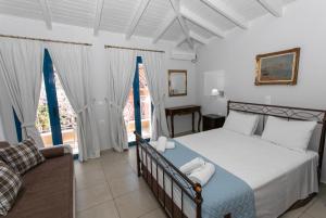 a bedroom with a bed and a couch at The Old Town hall in Parga