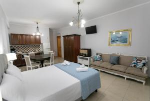 a bedroom with a bed and a couch and a table at The Old Town hall in Parga