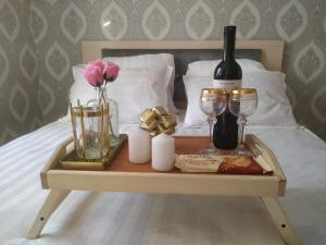 ein Tablett mit einer Flasche Wein und Gläsern auf dem Bett in der Unterkunft 2 комнатная в микрорайоне Шугыла in Qysylorda