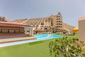 a swimming pool in front of a large building at Casa Sol de Jandía in Morro del Jable