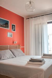 um quarto com paredes vermelhas e uma cama com uma janela em Magna Grecia B&B e Appartamenti em Caulonia Marina