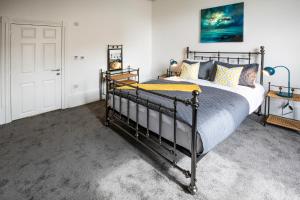 a bedroom with a bed with a metal frame at BrickSage Rooms, King's Lynn South Gate in King's Lynn