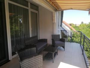 a balcony with chairs and a table on a balcony at Levente Apartman in Balatongyörök