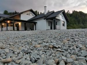 una casa con una gran pila de rocas delante de ella en Pensiunea Freya, en Colibiţa