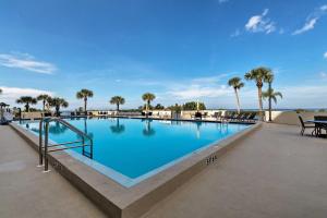 une grande piscine avec des palmiers en arrière-plan dans l'établissement Hudson Resort Condo with Private Beach Access!, à Hudson