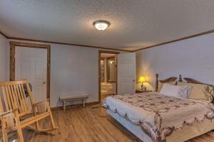 um quarto com uma cama e uma cadeira de madeira em Cozy Mead Home with Grill and Patio Nearby Lake! em Mead