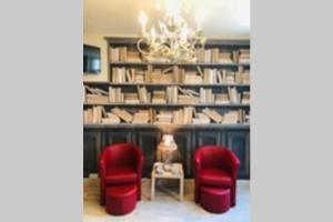 une chambre avec deux chaises rouges et une bibliothèque dans l'établissement Appartement familial de caractère, à Boulogne-sur-Mer