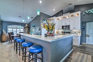 a kitchen with a large counter with blue stools at Florida Family Home with Private Pool and Dock! in Clermont