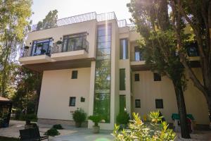 a large white building with a balcony and trees at Vila 6 Neptun Olimp in Olimp