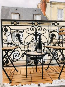 een tafel met een fles wijn op een balkon bij Le Tanin -Appartement entier avec Balcon in Saumur