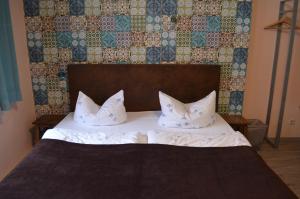 a bed with two pillows on it in a bedroom at Hotel Wittenberg-Hotel Garni in Lutherstadt Wittenberg