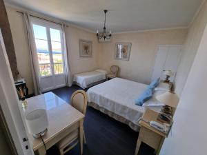 een kamer met 2 bedden, een tafel en een raam bij STELLA MARE in Algajola