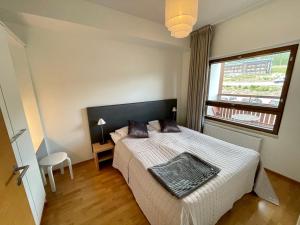 um quarto com uma cama grande e uma janela em Salomon Chalet 7207 - Parivuoteellinen makuuhuone ja lisäksi makuualkovi - Täydellinen pariskunnille ja perheille em Ylläsjärvi