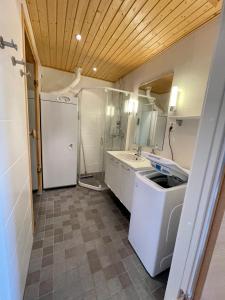 a kitchen with a white refrigerator and a sink at Salomon Chalet 7207 - Parivuoteellinen makuuhuone ja lisäksi makuualkovi - Täydellinen pariskunnille ja perheille in Ylläsjärvi