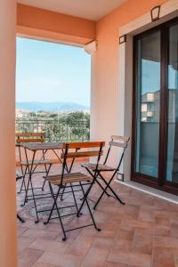 patio con mesa y sillas en el balcón en Magna Grecia B&B e Appartamenti, en Caulonia Marina